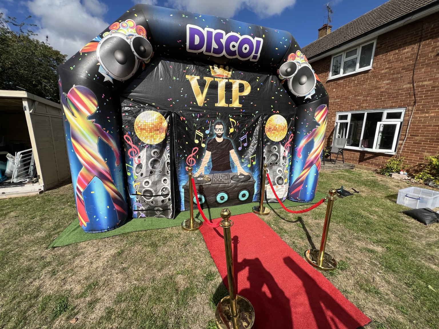 VIP disco inflatable with red carpet entrance in a sunny garden