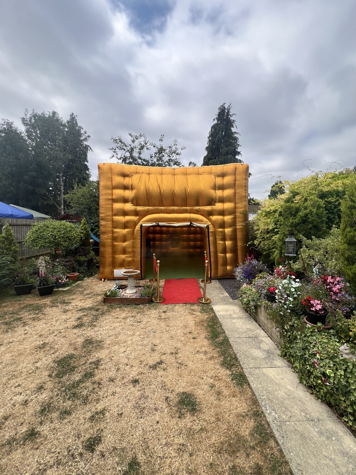 Gold inflatable nightclub with red carpet in a garden